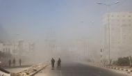 Palestinians walk away amid dust and smoke from the scene of an Israeli strike in Nuseirat in the central Gaza Strip on July 17, 2024. (Photo by Eyad Baba / AFP)