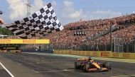 McLaren's Australian driver Oscar Piastri takes the chequered flag of the Formula One Hungarian Grand Prix at the Hungaroring race track in Mogyorod near Budapest on July 21, 2024. (Photo by MARTIN DIVISEK / POOL / AFP)