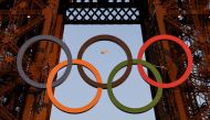 A helicopter flies around the Eiffel Tower with the Olympic rings displayed on it, in Paris on July 21, 2024, ahead of the Paris 2024 Olympic and Paralympic games. (Photo by Luis ROBAYO / AFP)