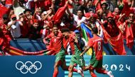 Morocco's forward #09 Soufiane Rahimi (left) celebrates with Morocco's forward #07 Eliesse Ben Seghir (centre) and Morocco's midfielder #08 Bilal El Khannouss after scoring a penalty and his team's second goal in the men's group B football match between Argentina and Morocco during the Paris 2024 Olympic Games at the Geoffroy-Guichard Stadium in Saint-Etienne on July 24, 2024. (Photo by Arnaud Finistre / AFP)