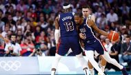 USA's Kevin Durant works around Serbia's #09 Vanja Marinkovic (Rear R) in the men's preliminary round group C basketball match between Serbia and USA during the Paris 2024 Olympic Games at the Pierre-Mauroy stadium in Villeneuve-d'Ascq, northern France, on July 28, 2024. (Photo by Sameer Al-Doumy / AFP)
