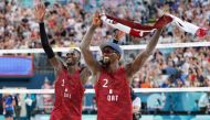 Qatar's #01 Cherif Younousse and Qatar's #02 Ahmed Tijan celebrate their victory in the men's pool A beach volleyball match between Sweden and Qatar during the Paris 2024 Olympic Games at the Eiffel Tower Stadium in Paris on July 29, 2024. (Photo by Luis Tato / AFP)