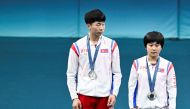 Silver medalists North Korea's Ri Jong Sik (L) and North Korea's Kim Kum Yong celebrate on the podium at the end of their mixed table tennis doubles competition at the Paris 2024 Olympic Games at the South Paris Arena in Paris on July 30, 2024. (Photo by WANG Zhao / AFP)
