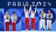 Silver medallists (L) North Korea's Jo Jin Mi and Kim Mi Rae, gold medallists (C) China's Chen Yuxi and Quan Hongchan and bronze medallists (R) Britain's Andrea Spendolini Sirieix and Lois Toulson celebrate on the podium following the women's synchronised 10m platform diving final at the Paris 2024 Olympic Games at the Aquatics Centre in Saint-Denis, north of Paris, on July 31, 2024. (Photo by SEBASTIEN BOZON / AFP)
