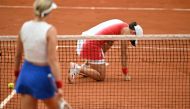 Poland's Iga Swiatek reacts after being struck by a ball hit back at her by US' Danielle Collins during their women's singles quarter-final tennis match on Court Suzanne-Lenglen at the Roland-Garros Stadium during the Paris 2024 Olympic Games, in Paris on July 31, 2024. (Photo by Patricia De Melo Moreira / AFP)