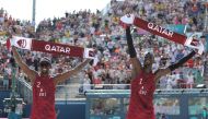 Qatar's #02 Ahmed Tijan and Qatar's #01 Cherif Younousse celebrate their victory in the men's pool A beach volleyball match between Qatar and Australia during the Paris 2024 Olympic Games at the Eiffel Tower Stadium in Paris on August 1, 2024. Photo by Thomas SAMSON / AFP.