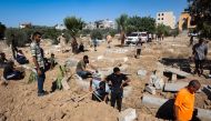 Palestinians dig graves at the al-Zawaida Cemetery, after the Israeli bombardment of the al-Bureij refugee Camp, in the central Gaza Strip on July 31, 2024. (Photo by Eyad Baba / AFP)