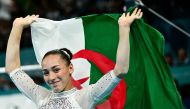 Algeria's Kaylia Nemour celebrates after winning the artistic gymnastics women's uneven bars final during the Paris 2024 Olympic Games at the Bercy Arena in Paris, on August 4, 2024. (Photo by Loic VENANCE / AFP)
