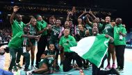 Nigeria's players and staff pose as they celebrate after winning the women's preliminary round group B basketball match between Canada and Nigeria during the Paris 2024 Olympic Games at the Pierre-Mauroy stadium in Villeneuve-d'Ascq, northern France, on August 4, 2024. (Photo by Sameer Al-Doumy / AFP