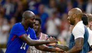 France's forward #14 Jean-Philippe Mateta celebrates scoring his team's second goal with France's coach Thierry Henry during the men's semi-final football match between France and Egypt during the Paris 2024 Olympic Games at the Lyon Stadium in Lyon on August 5, 2024. (Photo by Olivier CHASSIGNOLE / AFP)
