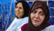 An injured woman reacts after identifying a member of her family among the dead at the al-Maamadani hospital, following an Israeli strike that killed more than 90 people on a school sheltering displaced Palestinians in Gaza City on August 10, 2024. Photo by Omar AL-QATTAA / AFP.