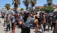 Palestinians transport people injured in Israeli bombardment to the Al-Aqsa Martyrs hospital in Deir el-Balah in the central Gaza Strip on August 13, 2024 amid the ongoing conflict between Israel and the Palestinian Hamas movement. (Photo by Eyad BABA / AFP)
