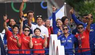 Philippines' Carlos Yulo (C), Paris 2024 Olympic Games double gold medalist in gymnastics, and other Philippine athletes who competed at Paris 2024 Olympics, wave from a float during a celebratory homecoming parade along a street in Manila on August 14, 2024. (Photo by Ted ALJIBE / AFP)