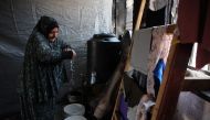 Displaced Palestinian Nazek Abu Shmala washes clothes inside a flat in the Jabalia refugee camp in the northern Gaza Strip where she's temporarily sheltering with her family on August 15, 2024,amid the conflict between Israel and Hamas militants. (Photo by Omar AL-QATTAA / AFP)