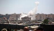 Displaced Palestinians watch from a makeshift camp as shells fired from Israeli tanks hit an area near the Hamad residential complex in Khan Yunis in the southern Gaza Strip on August 18, 2024, amid the ongoing conflict between Israel and the Hamas militant group. (Photo by Bashar TALEB / AFP)
