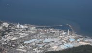 This aerial picture shows storage tanks (bottom) used for storing treated water at TEPCO's crippled Fukushima Daiichi Nuclear Power Plant in Okuma, Fukushima prefecture on August 24, 2023. (Photo by JIJI PRESS / AFP)

