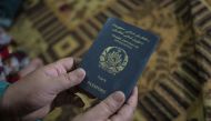 A woman holds an Afghan passport in Islamabad, Pakistan, in 2023. (Photo by Saiyna Bashir for The Washington Post)

