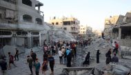 Palestinians gather to check a building shortly after it was levelled by Israeli bombing in the Nuseirat refugee camp in the central Gaza Strip on August 22, 2024. (Photo by Eyad BABA / AFP)
