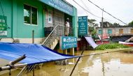 A man looks out from the porch of a bank partially submerged in floodwaters at Feni on August 24, 2024. (Photo by Munir UZ ZAMAN / AFP)