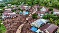 This aerial view shows rescue teams and residents searching for victims buried in mud after a flashflood hit the village of Rua located at the foot of Mount Gamalama, in Ternate, North Maluku on August 25, 2024. (Photo by AZZAM RISQULLAH / AFP)