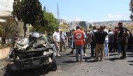 Lebanese security and emergency personnel gather around a burnt car that was reportedly targeted in an Israeli drone strike in the Abra area of the southern city of Sidon, on August 26, 2024. (Photo by Mahmoud ZAYYAT / AFP)
