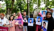 Relatives hold portraits of forcibly disappeared people, as they form a human chain to mark the International Day of the Victims of Enforced Disappearances, in Dhaka on August 30, 2024. (Photo by MUNIR UZ ZAMAN / AFP)
