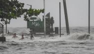 Youths wade in a storm surge along Manila Bay amid heavy rains brought by Tropical Storm Yagi in Manila on September 2, 2024. Photo by JAM STA ROSA / AFP