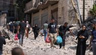 Palestinians walk on a street torn up by bulldozers after an Israeli raid in the eastern neighbourhood of Jenin city in the occupied West Bank, yesterday. (AFP)