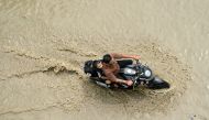 A motorcyclist rides through a flooded street after heavy monsoon rains in Amritsar on August 29, 2024. Photo by Narinder NANU / AFP.
