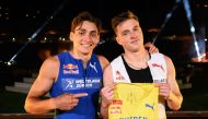 Swedish pole vaulter Armand Duplantis (L) presents a Sweden jersey to be worn by Norwegian hurdler and sprinter Karsten Warholm after winning a head-to-head exhibition 100m sprint race on the sideline of the IAAF Diamond League 