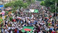 Demonstrators carry Bangladesh's national flag (front) during 'Martyr March', a rally organised by Students Against Discrimination to mark one month to the ousting of the country's former Prime Minister Sheikh Hasina, in Dhaka on September 5, 2024.  (Photo by Munir Uz Zaman / AFP)