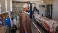 A Palestinian worker stands at a morgue near a body in a hospital following Israeli bombardment, on September 7, 2024. Photo by Eyad BABA / AFP.
