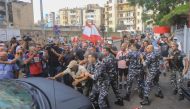 Protesters try to block a security forces convoy entering the Palace of Justice in Beirut. (Photo by AFP)