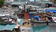 A man walks through floodwaters past partially submerged houses in Hanoi on September 10, 2024, after typhoon Yagi hit Vietnam. Photo by Nhac NGUYEN / AFP