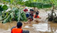 Residents are helped through high flood waters by police in Pyinmana town in Myanmar's Naypyidaw region on September 13, 2024, following heavy rains in the aftermath of Typhoon Yagi. (Photo by Sai Aung Main / AFP)