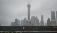 A man walks along The Bund during the passage of Typhoon Bebinca in Shanghai on September 16, 2024. Photo by Hector RETAMAL / AFP.