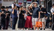 File picture: People wait to cross a street during hot weather in Tokyo on September 19, 2024. (Photo by Yuichi Yamazaki / AFP)