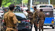 Sri Lankan police combat officers inspect a car at a road checkpoint ahead of the upcoming presidential elections, in Colombo on September 19, 2024. (Photo by Ishara S. Kodikara / AFP)