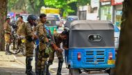 Sri Lankan police combat officers inspect an auto-rickshaw at a road checkpoint ahead of the upcoming presidential elections, in Colombo on September 19, 2024. (Photo by Ishara S Kodikara / AFP)