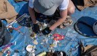 Laurence Martel, Plastic Pollution Coordinator of the Blue Organization sorts through trash collected on the shore and in the water of the Saguenay Fjord during the Blue Expedition, in Petit-Saguenay, Quebec, Canada, July 24, 2024. (Photo by Sebastien ST-JEAN / AFP)