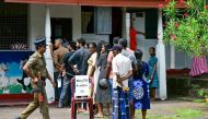 People wait in a queue to cast their ballots at a polling station as police keep watch during voting in Sri Lanka's presidential election in Colombo on September 21, 2024. (Photo by Ishara S. Kodikara / AFP)