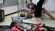 Graphic content / A dead child lies on the ground as a young Palestinian girl receives medical care for her injuries sustained in an Israeli strike near Khan Yunis in the southern Gaza Strip, at the Nasser hospital on September 18, 2024. Photo by Bashar TALEB / AFP.