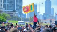 A supporter of Sri Lanka's newly elected President Anura Kumara Dissanayaka, waves country's national flag near the Presidential Secretariat after Dissanayaka's swearing-in ceremony in Colombo on September 23, 2024. Photo by Ishara S. Kodikara / AFP.