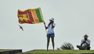 Photo used for a demonstration purpose. A woman with a Sri Lankan national flag stands at the Galle fort while watching the play of the fourth day of first Test cricket match between Sri Lanka and New Zealand at the Galle International Cricket Stadium in Galle on September 22, 2024. Photo by IDREES MOHAMMED / AFP.