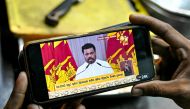 A vendor watches a live telecast as Sri Lanka's newly elected President Anura Kumara Dissanayake addresses the nation, at Galle Face Beach in Colombo on September 25, 2024. (Photo by Idrees MOHAMMED / AFP)
