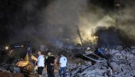 Rescuers stand on the rubble of a builiding destroyed in an Israeli air strike in the Haret Hreik neighbourhood of Beirut's southern suburbs on September 27, 2024. (Photo by AFP)
