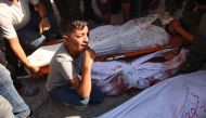  Graphic content / A child reacts as he sits between bodies at the morgue of the Kamal Radwan hospital following an Israeli strike on a school sheltering displaced Palestinians in Falluja near the Jabalia refugee camp in the norther Gaza Strip on September 26, 2024. Photo by Omar AL-QATTAA / AFP.