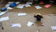 A man carrying a sack of flour wades through flood waters after the Bagmati River overflowed following heavy monsoon rains in Kathmandu on September 28, 2024. Photo by PRAKASH MATHEMA / AFP