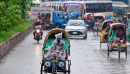 Bangladeshi rickshaw pullers ride along a street, amid rainfall in Dhaka on September 25, 2024. (Photo by MUNIR UZ ZAMAN / AFP)
