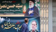 A man walks past banners in Tehran bearing pictures of slain Lebanese Hezbollah leader Hassan Nasrallah (top) and Iran's paramilitary Revolutionary Guard general Abbas Nilfrushan, two days after their targeted assassination by Israeli forces in Beirut's southern suburbs, on September 29, 2024. Photo by ATTA KENARE / AFP.